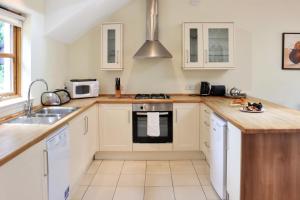 a kitchen with white cabinets and a sink at Lodges by Atholl Palace in Pitlochry