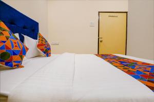 um quarto com uma cama e uma porta amarela em FabExpress Kurla Inn em Mumbai