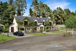a house with a car parked in front of it at Lodges by Atholl Palace in Pitlochry