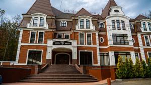 a large brick building with stairs in front of it at Park Hotel Bristol in Uzhhorod