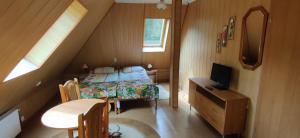a bedroom with a bed and a desk with a television at Dom Wczasowy Bałtyk in Ustronie Morskie