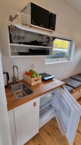 a kitchen with a counter with a sink and a microwave at Beach-near cozy cottage in Höllviken