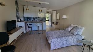 a bedroom with a bed and a kitchen with a counter at "Côté Gibaou" Centre-ville Garage Piscine Terrasse in Cassis