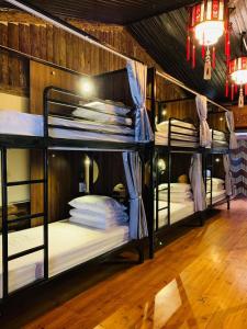 two bunk beds in a room with wooden floors at Mai's Homestay Dong Van in Dồng Văn