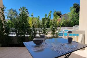 a blue table with plates and bowls on a balcony at "Côté Gibaou" Centre-ville Garage Piscine Terrasse in Cassis