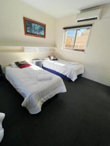 a room with two beds and a window at Bairnsdale Town Central Motel in Bairnsdale