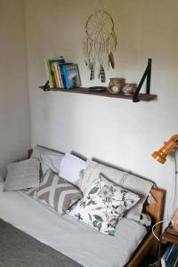 ein Regal über einer Couch mit Kissen drauf in der Unterkunft Powoli - wyjątkowy domek w Izerach in Wolimierz