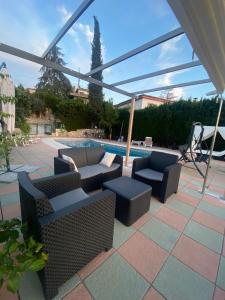 patio z kanapami i krzesłami przy basenie w obiekcie El Mirador de Santiago w mieście Monachil