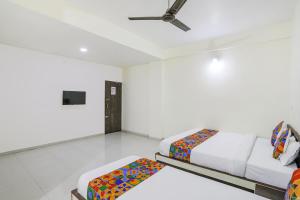 1 Schlafzimmer mit 2 Betten und einem Deckenventilator in der Unterkunft FabExpress Park View in Rāipur