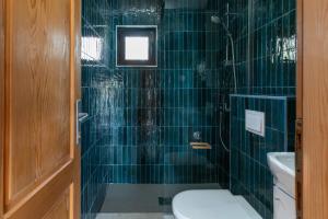 a green tiled bathroom with a toilet and a sink at Bel Assis in Ulcinj