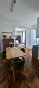sala de estar con mesa de madera y sillas verdes en Apartment Eufemia, en Kanfanar