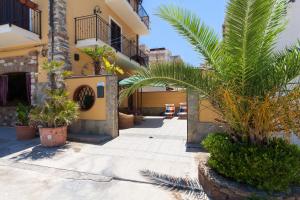 a courtyard of a house with palm trees and plants at Loft Sul Mare in Balestrate
