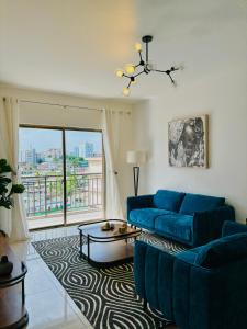 Una sala de estar con un sofá azul y una ventana. en HAYDEN HOME, en Libreville