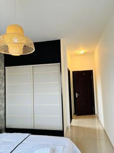 a bedroom with a white garage door and a chandelier at HAYDEN HOME in Libreville