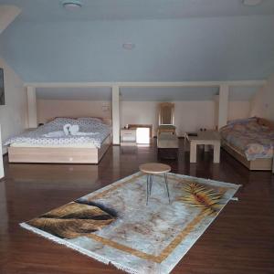 a bedroom with two beds and a table and a rug at Zezo Apartments in Bitola