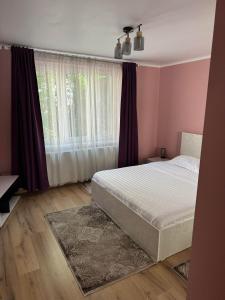 a bedroom with a bed and a large window at Pretty Luxury Apartament's in Cluj-Napoca