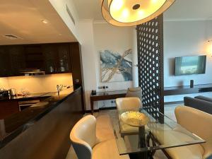 een woonkamer met een glazen tafel en stoelen bij 1 Bed Apartment-Rixos Fairmont Residences in Abu Dhabi