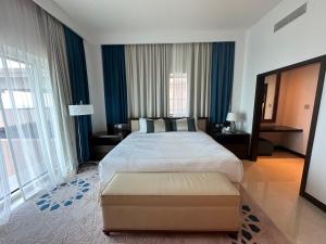 a bedroom with a large bed and a large window at 1 Bed Apartment-Rixos Fairmont Residences in Abu Dhabi
