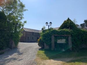 an entrance to a house with an ivy covered driveway at Rescorla Retreats - Wisteria in St Austell