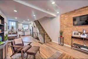 a large living room with a brick wall at Modern South Philly Townhome in Philadelphia