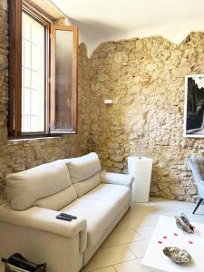 sala de estar con sofá y pared de piedra en Suite In Love 21, en Casale Marittimo