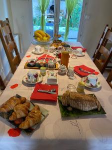 een tafel met brood en ander voedsel erop bij LE CLOS D'HERBLAY Chambres d'Hôtes in Herblay