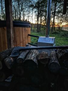 una pila di tronchi davanti a una griglia di Na.Zadkach a Klon Altre 46 foto