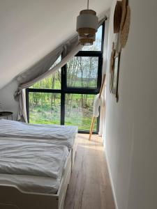 a bedroom with a bed and a large window at Na.Zadkach 