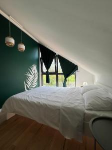 a bedroom with a white bed and a green wall at Na.Zadkach 