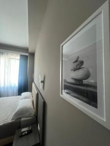 a bedroom with a picture of three rocks at Sunset Guest House in Reggio di Calabria