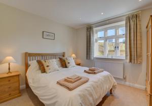 a bedroom with a bed with two towels on it at Mill Cottage in Elsing