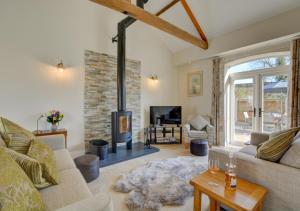 a living room with a fireplace and a couch at Mill Cottage in Elsing