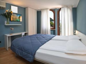 Un dormitorio con una cama grande y una ventana en Albergo All'Ancora, en Garda