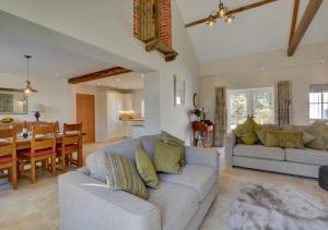 a living room with a couch and a dining room at Mill Cottage in Elsing