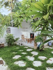 a garden with a fireplace and a table and chairs at Balla Naila in Gili Trawangan
