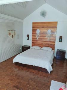 - une chambre avec un grand lit et une tête de lit en bois dans l'établissement Balla Naila, à Gili Trawangan