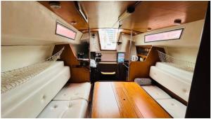 um interior de uma caravana com duas camas e uma mesa de madeira em Barcelona Hotel Sailboat em Barcelona