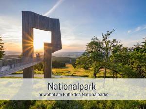 een bord dat nationaal park leest Een ritje waard bij Natur-Chalet zum Nationalpark Marie-Luise inkl E-Auto in Allenbach