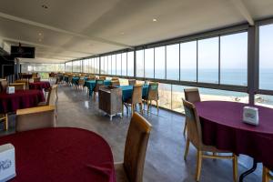 トラブゾンにあるMora Hotelのテーブルと椅子が備わり、海の景色を望むレストラン