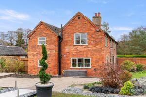NewboroughにあるLuxury cottage, 8 guests, 4 bedrooms, Staffordshireの庭に窓のあるレンガ造りの家