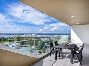 a dining room with a table and chairs on a balcony at Sweeping Ocean view Apt w Carpark and rooftop pool in Gold Coast