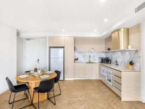 a kitchen with a table and chairs in a kitchen at Sweeping Ocean view Apt w Carpark and rooftop pool in Gold Coast