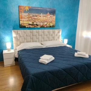 Serravalle Pistoiese的住宿－Hotel Alba Serravalle，一间卧室配有蓝色的床和2条毛巾