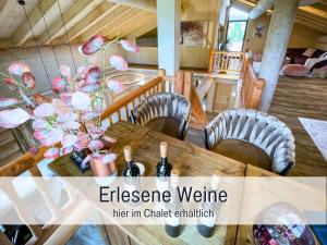 ein Esszimmer mit einem Tisch, Stühlen und Weinflaschen in der Unterkunft Natur-Chalet zum Nationalpark Marie-Luise inkl E-Auto in Allenbach