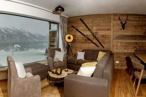 a living room filled with furniture and a large window at Kitzb heler Alpenlodge Top A6 with private panoramic sauna in Mittersill