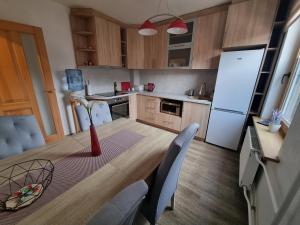 a kitchen with a white refrigerator and a table and chairs at Apartment Kurši in Kolka +7 photos