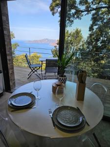 una mesa blanca con dos platos y copas de vino en U Paradisu en Piana