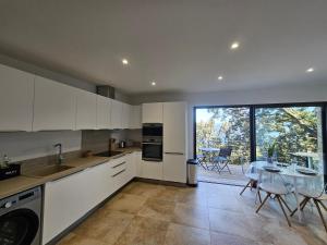 Una cocina con gabinetes blancos y una mesa con sillas. en U Paradisu, en Piana