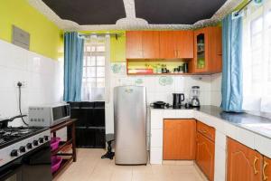 eine Küche mit einem Kühlschrank und einer Mikrowelle in der Unterkunft Spacious 2-BR Apartment In Membley in Ruiru