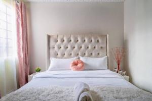 ein Schlafzimmer mit einem großen Bett mit einem rosa Ball drauf in der Unterkunft Spacious 2-BR Apartment In Membley in Ruiru